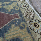 Close-up of the red vintage Turkish persian rug showing traditional details, hand-knotted weave, wool and cotton and low pile.