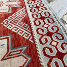 Close-up of the red vintage persian rug showing traditional details, hand-knotted weave, wool and cotton and low pile.