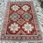 Red 5' x 6' vintage persian rug in wool and cotton, shown on the floor.