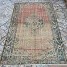 Red 5' x 7' vintage Turkish persian rug in wool and cotton, shown on the floor.