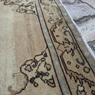 Close-up of the beige vintage Turkish persian rug showing neutral details, hand-knotted weave, wool and cotton and low pile.