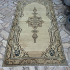 Beige 5' x 8' vintage Turkish persian rug in wool and cotton, shown on the floor.
