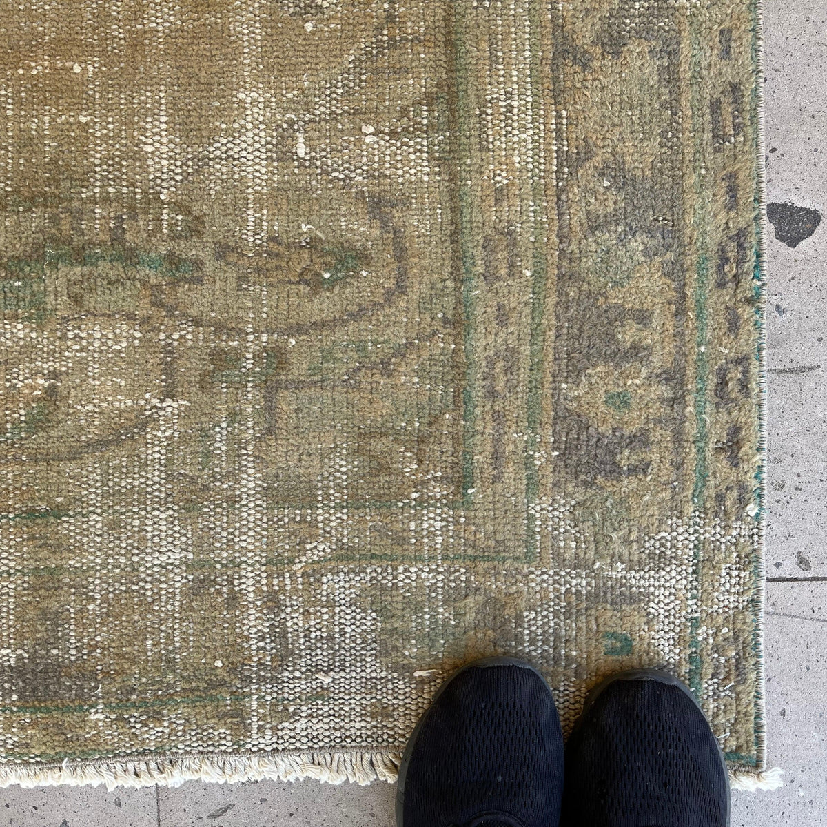 Close-up of the beige vintage Turkish persian rug showing medallion details, hand-knotted weave, wool and cotton and low pile.