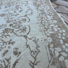 Close-up of the beige vintage Turkish persian rug showing neutral details, hand-knotted weave, wool and cotton and low pile.
