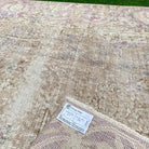 Close-up of the beige vintage Turkish persian rug showing medallion details, hand-knotted weave, wool and cotton and low pile.
