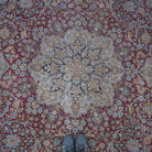 Red 9' x 12' vintage persian rug in wool and cotton, shown on the floor.
