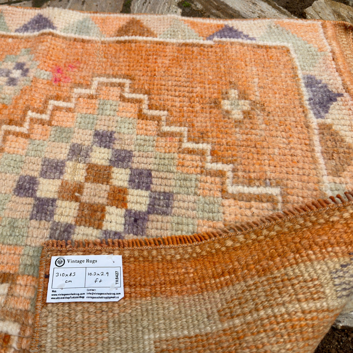 Close-up of the orange vintage persian runner rug showing traditional details, hand-knotted weave, wool and cotton and medium pile.