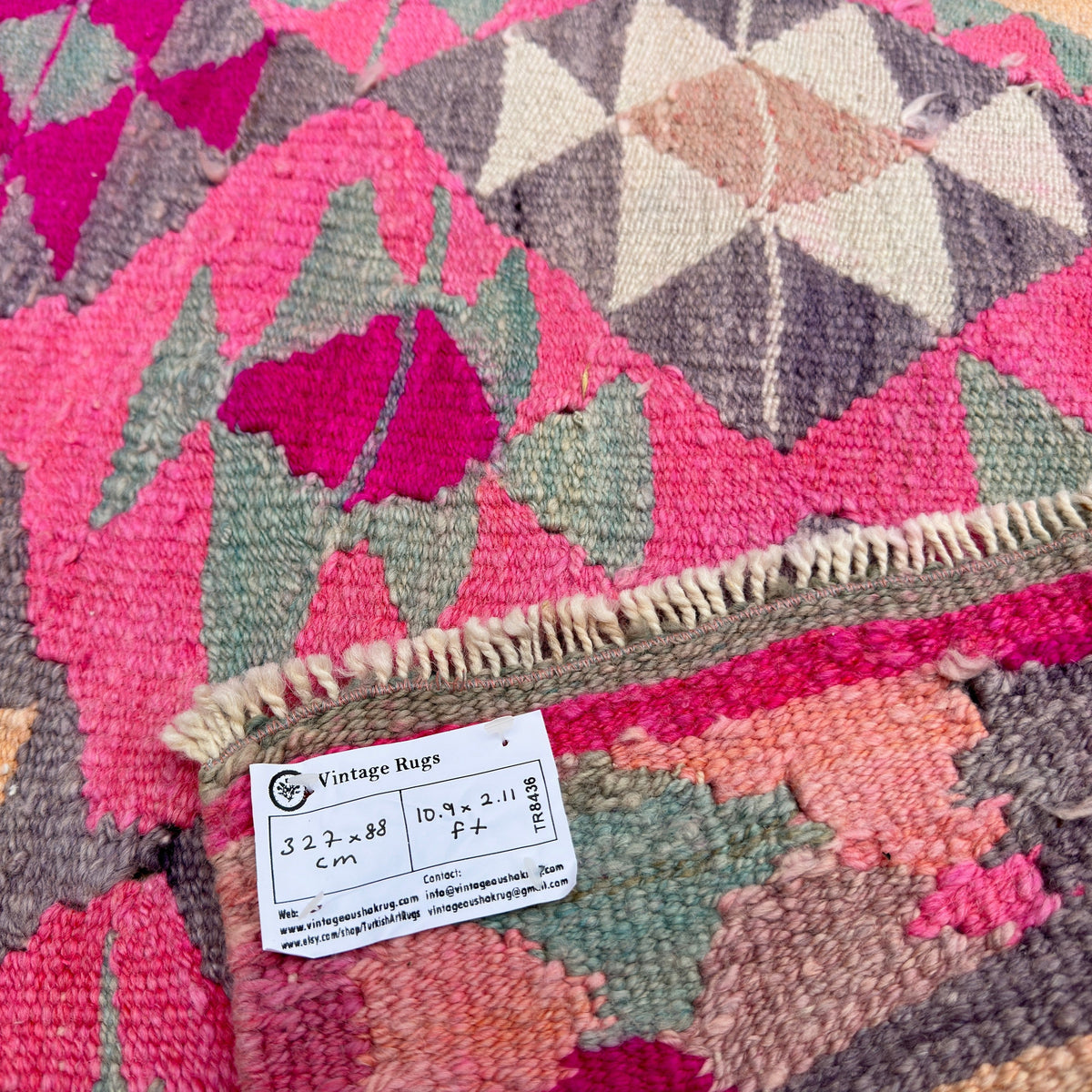 Close-up of the pink vintage persian runner rug showing medallion details, hand-knotted weave, wool and cotton and low pile.