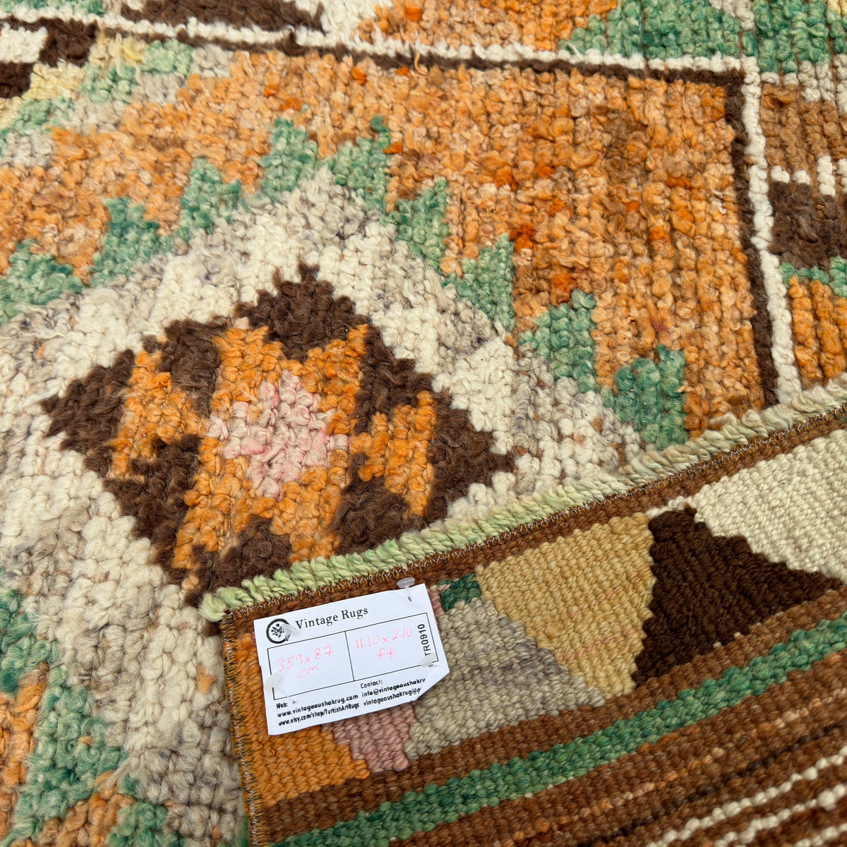 Close-up of the orange vintage persian runner rug showing traditional details, hand-knotted weave, wool and cotton and medium pile.
