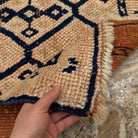 Close-up of the pale orange vintage persian runner rug showing traditional details, hand-knotted weave, wool and low pile.