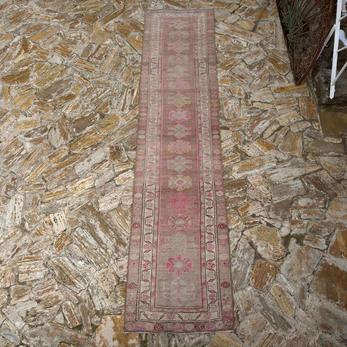 Close-up of the pink vintage persian runner rug showing traditional details, hand-knotted weave, wool and cotton and low pile.