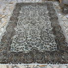 Brown 6' x 10' vintage Turkish persian style rug in wool and cotton, shown on the floor.