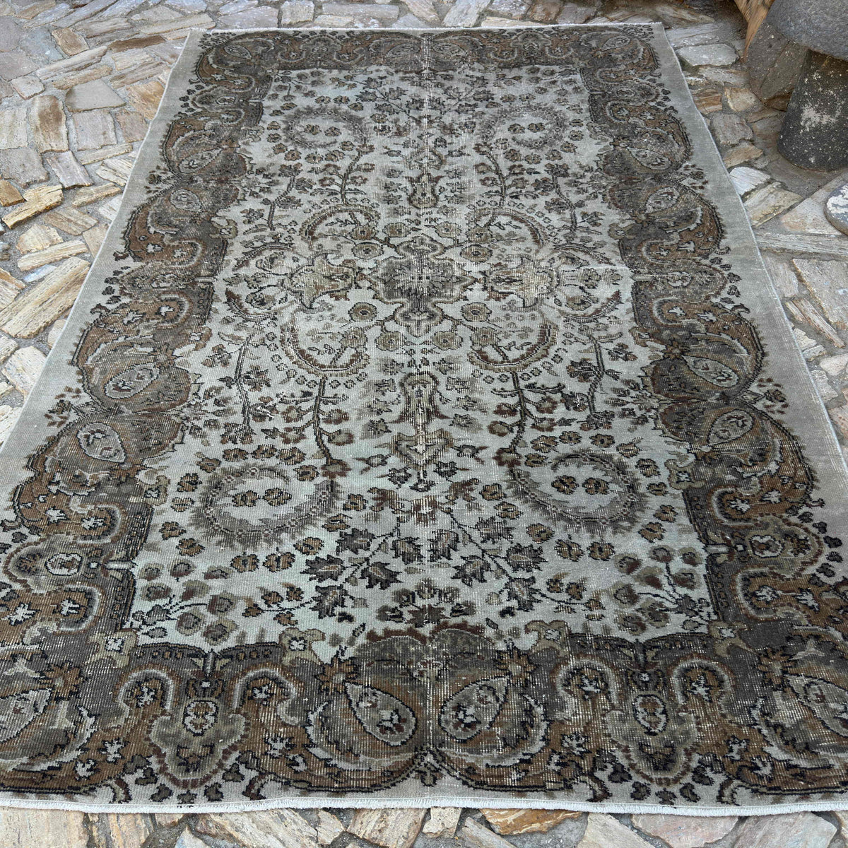 Brown 6' x 10' vintage Turkish persian style rug in wool and cotton, shown on the floor.