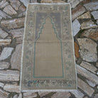 Beige 2' x 4' vintage Turkish prayer rug in wool and cotton, shown on the floor.