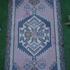 Close-up of the pink vintage Turkish rug showing traditional details, hand-knotted weave, wool and cotton and low pile.