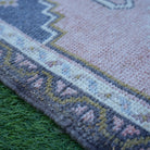 Pink 2' x 4' vintage Turkish rug in wool and cotton, shown on the floor.