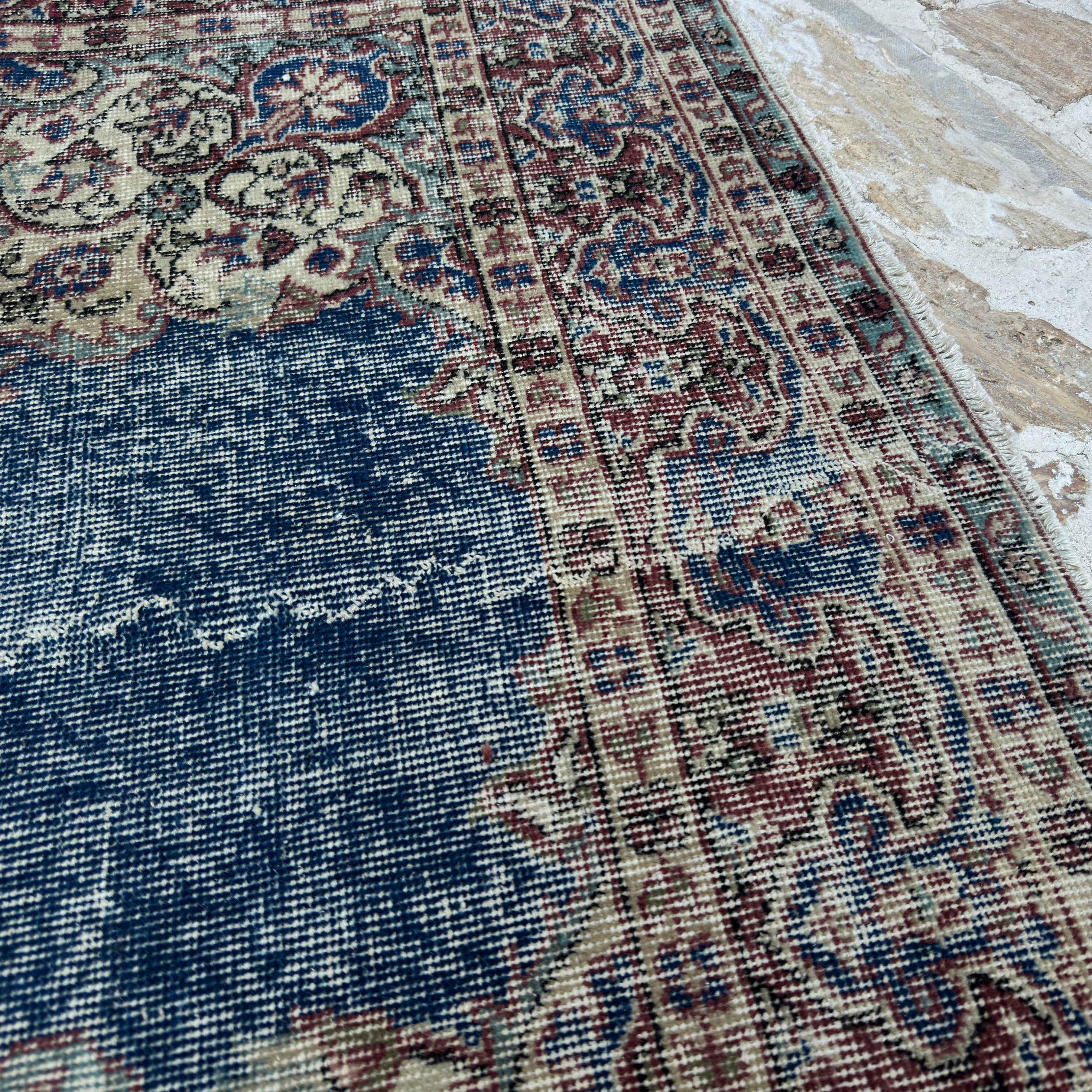 Close-up of the blue vintage Turkish rug showing medallion details, hand-knotted weave, wool and cotton and low pile.