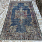 Blue 5' x 8' vintage Turkish rug in wool and cotton, shown on the floor.