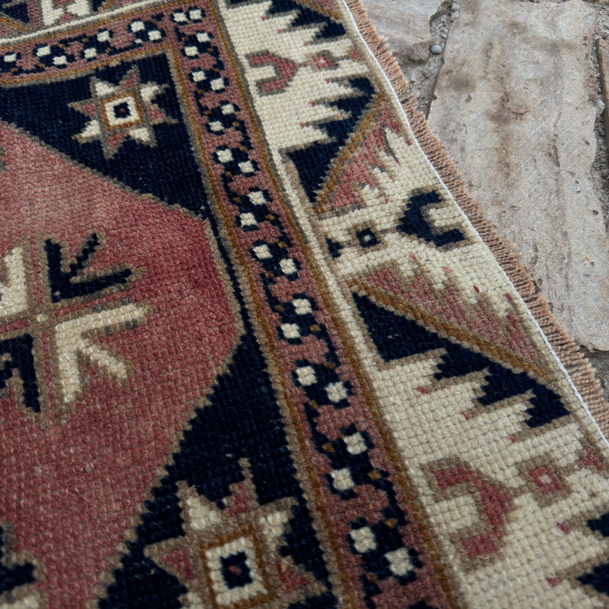 Close-up of the pale red vintage Turkish runner rug showing traditional details, hand-knotted weave, wool and cotton and low pile.