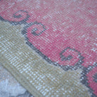 Pink 2' x 8' vintage Turkish runner rug in wool and cotton, shown on the floor.