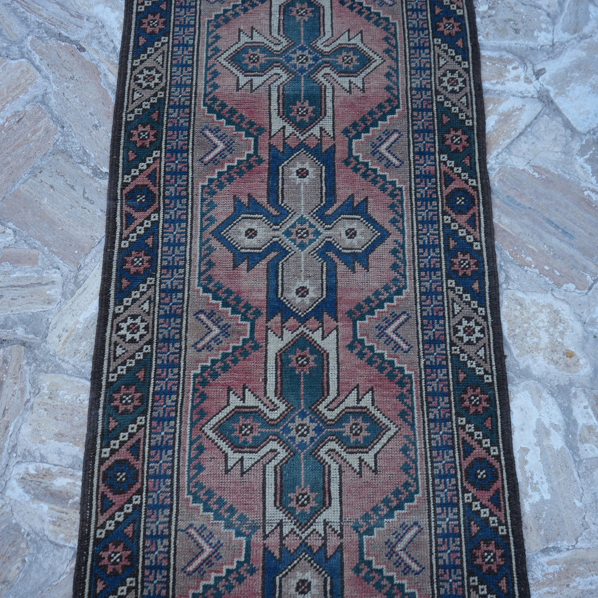 Close-up of the red vintage Turkish runner rug showing traditional details, hand-knotted weave, wool and low pile.