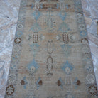 Close-up of the beige vintage Turkish runner rug showing floral details, hand-knotted weave, wool and cotton and low pile.