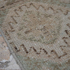 Beige 3' x 11' vintage Turkish runner rug in wool, shown on the floor.