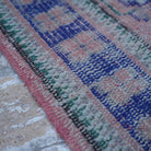 Pink 3' x 11' vintage Turkish runner rug in wool and cotton, shown on the floor.