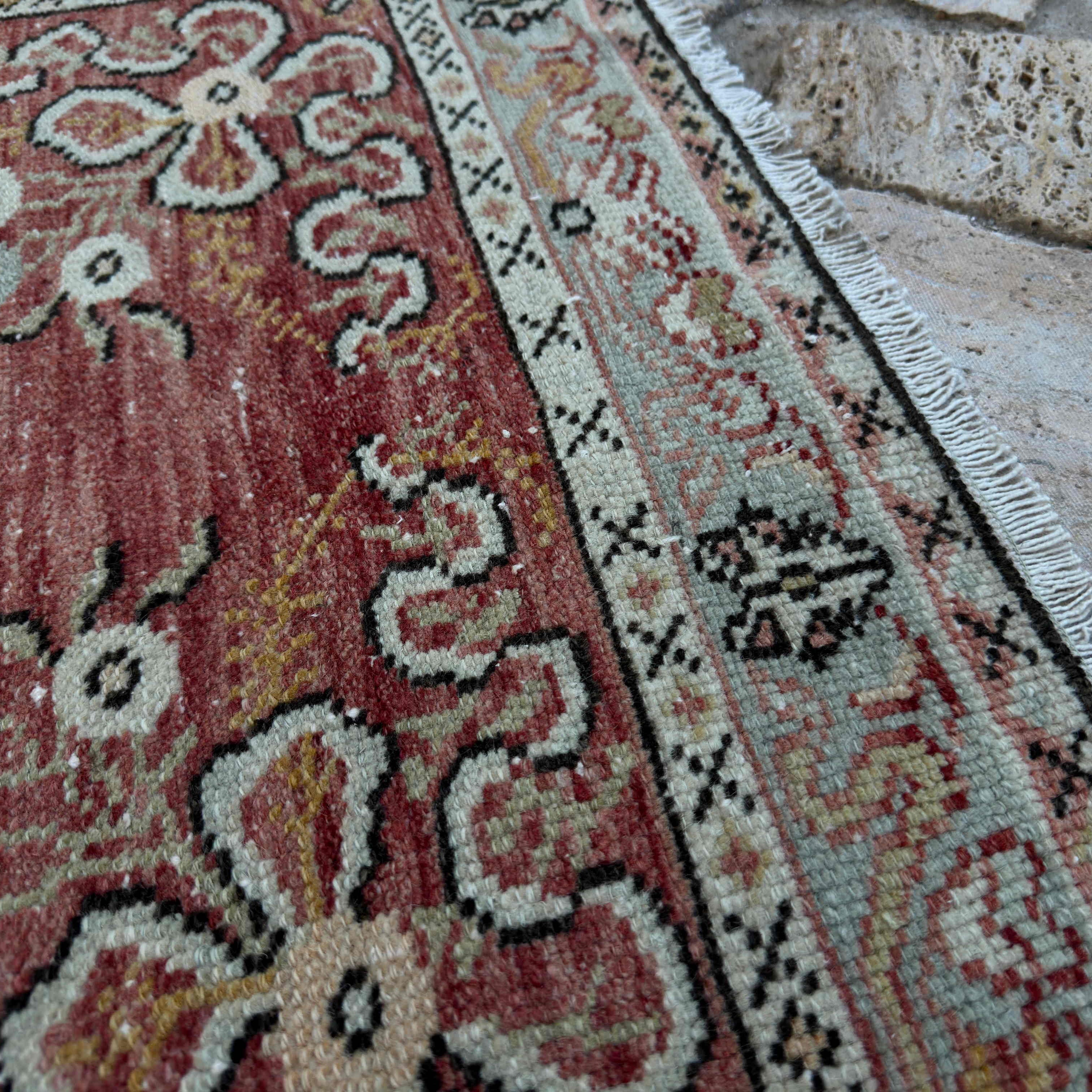 Close-up of the red vintage Turkish runner rug showing traditional details, hand-knotted weave, wool and cotton and low pile.