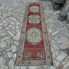 Red 3' x 12' vintage Turkish runner rug in wool and cotton, shown on the floor.