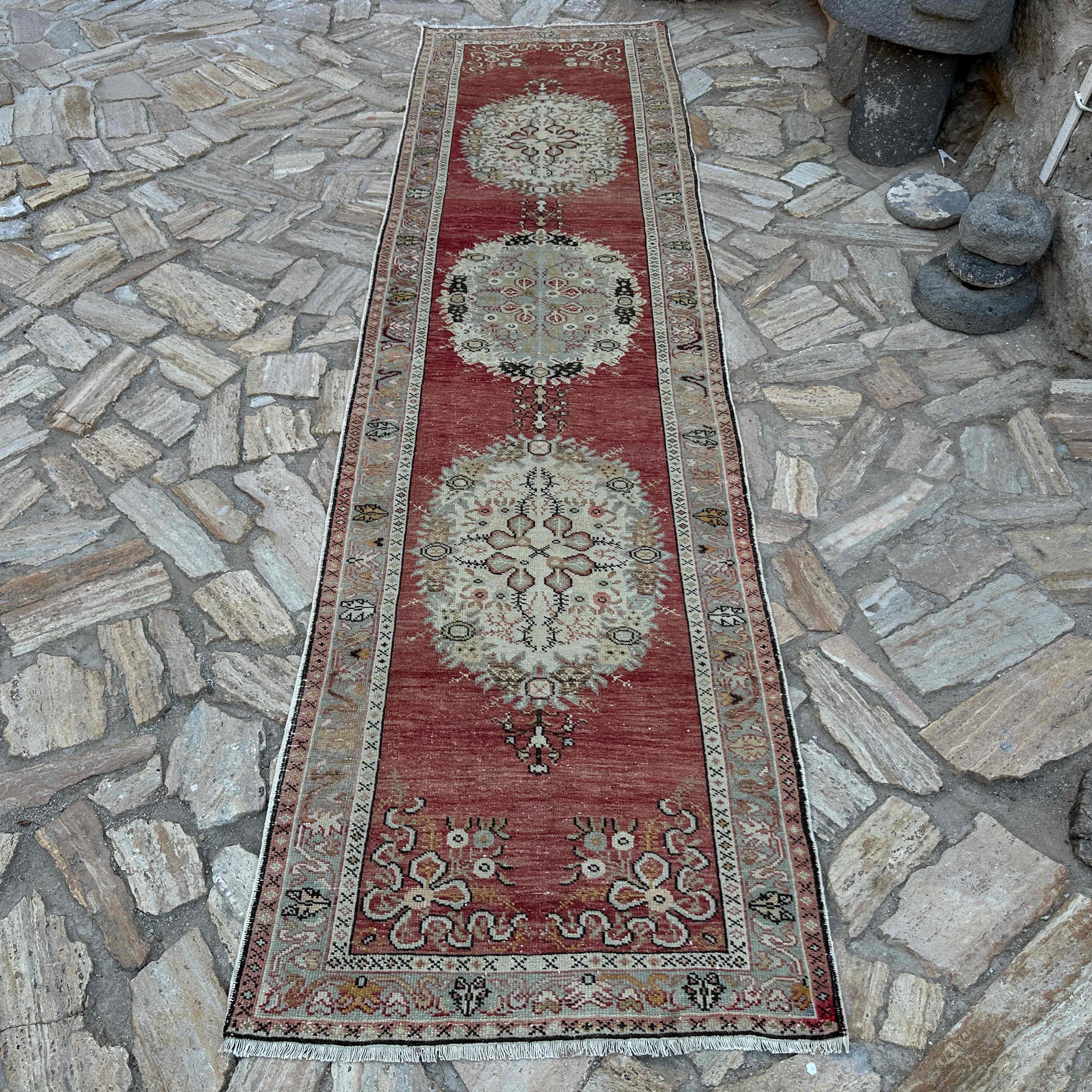 Red 3' x 12' vintage Turkish runner rug in wool and cotton, shown on the floor.