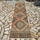 Orange 3' x 13' vintage Turkish runner rug in wool and cotton, shown on the floor.