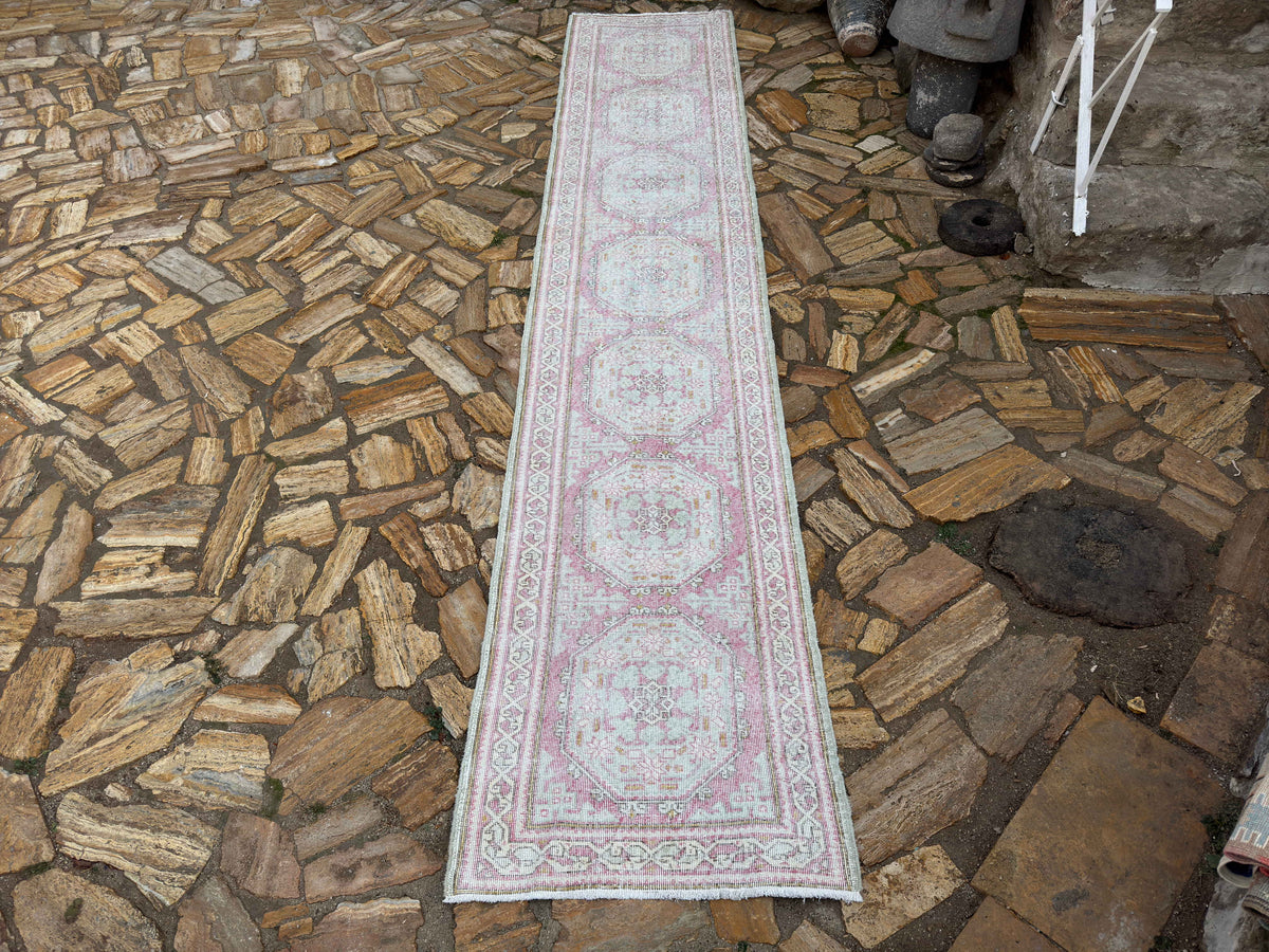 Pale Pink 3' x 14' vintage Turkish runner rug in wool and cotton, shown on the floor.