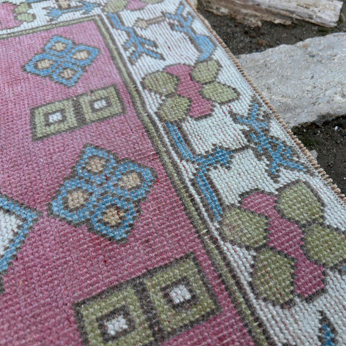Close-up of the pink vintage Turkish runner rug showing traditional details, hand-knotted weave, wool and cotton and low pile.