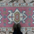 Pink 3' x 8' vintage Turkish runner rug in wool and cotton, shown on the floor.