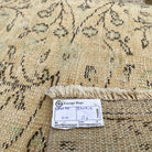 Close-up of the beige vintage Turkish runner rug showing floral details, hand-knotted weave, wool and cotton and low pile.