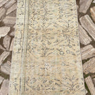1970s beige vintage Turkish runner rug with floral design, hand-knotted weave and low pile.