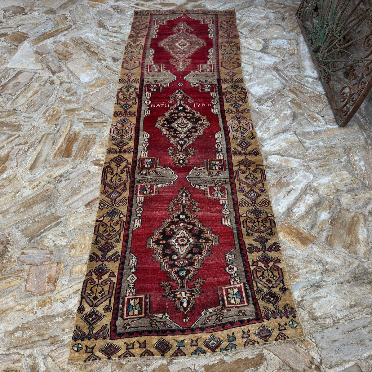 Close-up of the red vintage Turkish runner rug showing traditional details, hand-knotted weave, wool and cotton and low pile.