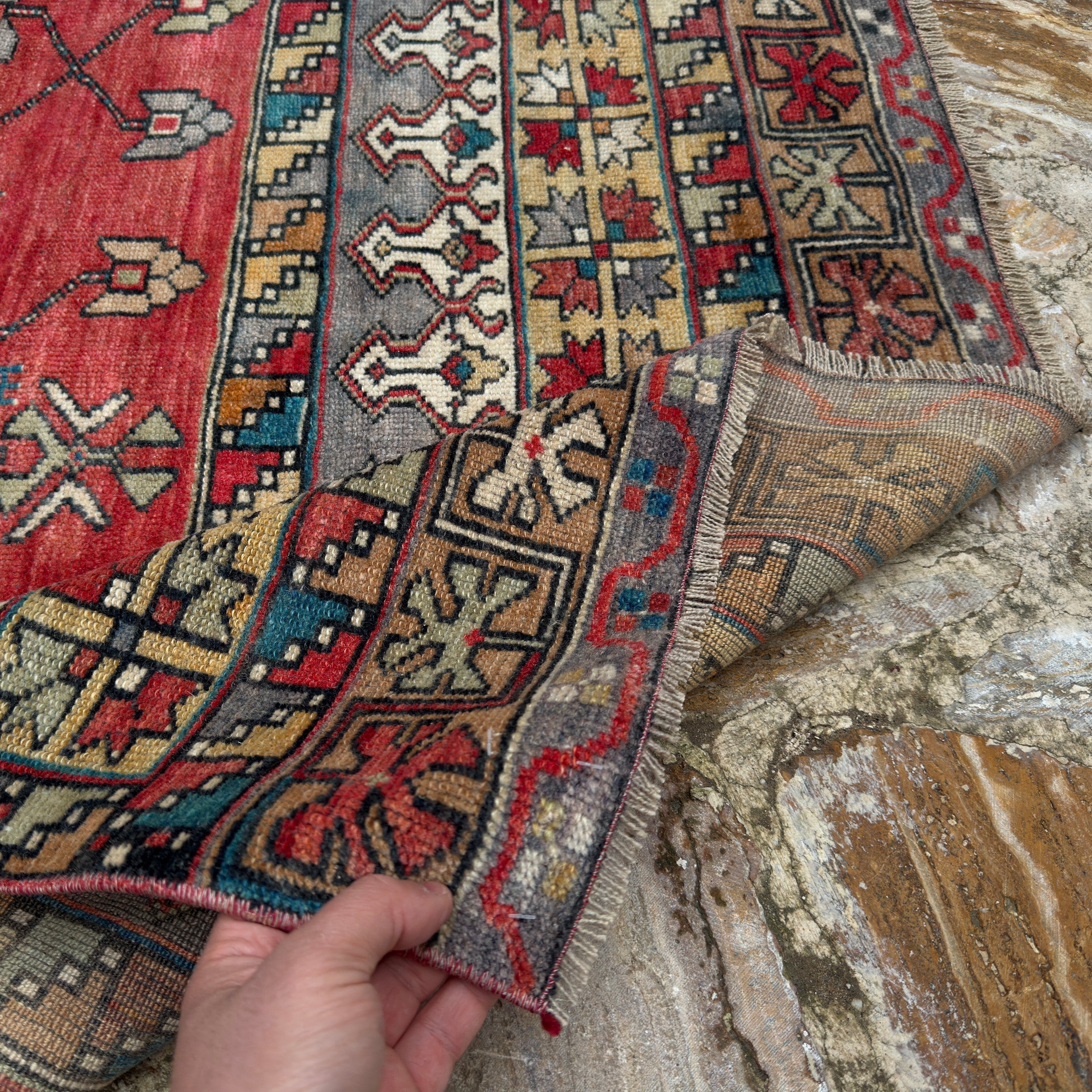 Close-up of the red vintage Turkish runner rug showing traditional details, hand-knotted weave, wool and low pile.