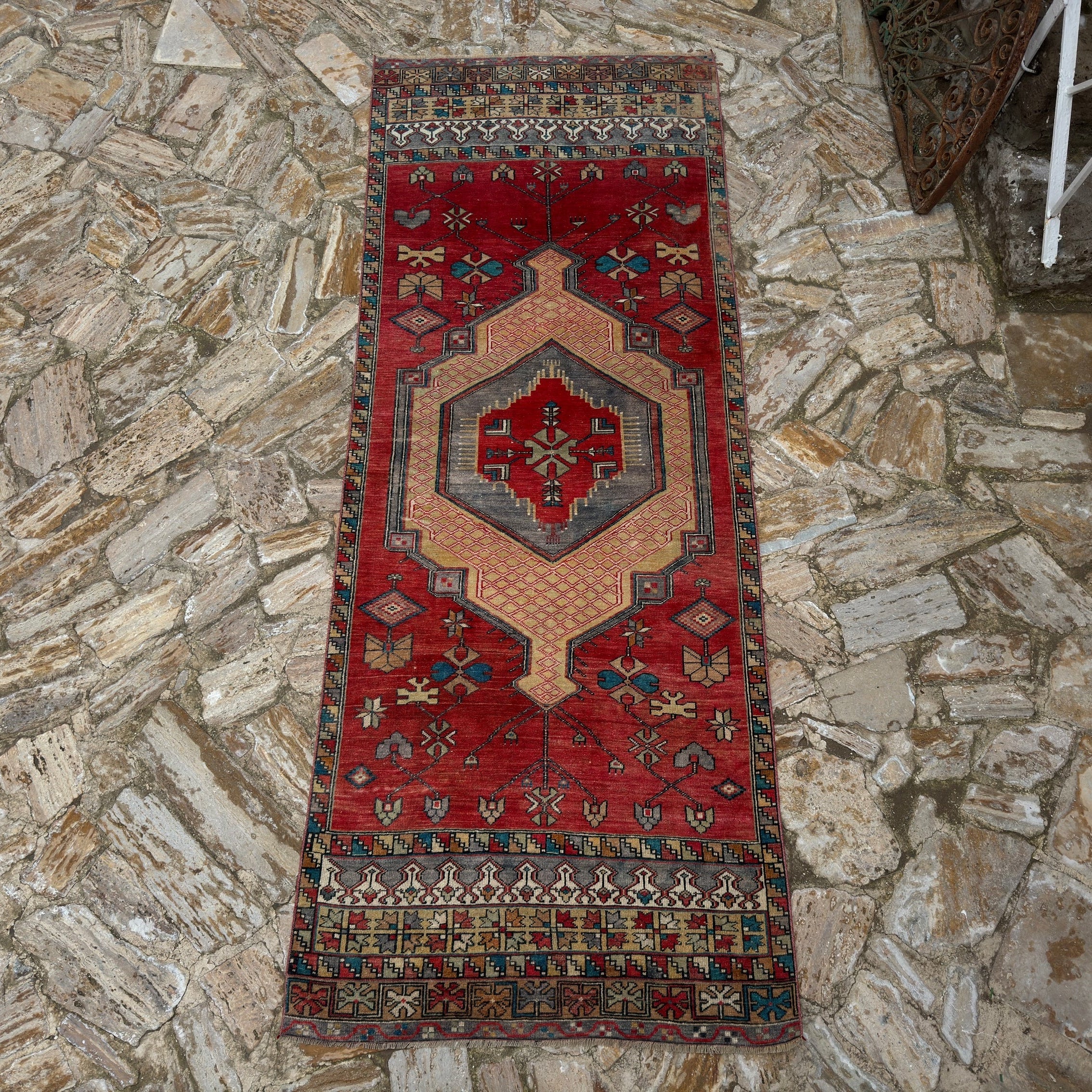 Red 4' x 10' vintage Turkish runner rug in wool, shown on the floor.