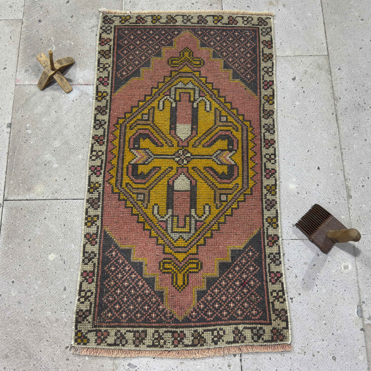 Pink 2' x 3' vintage Turkish small carpet in wool and cotton, shown on the floor.
