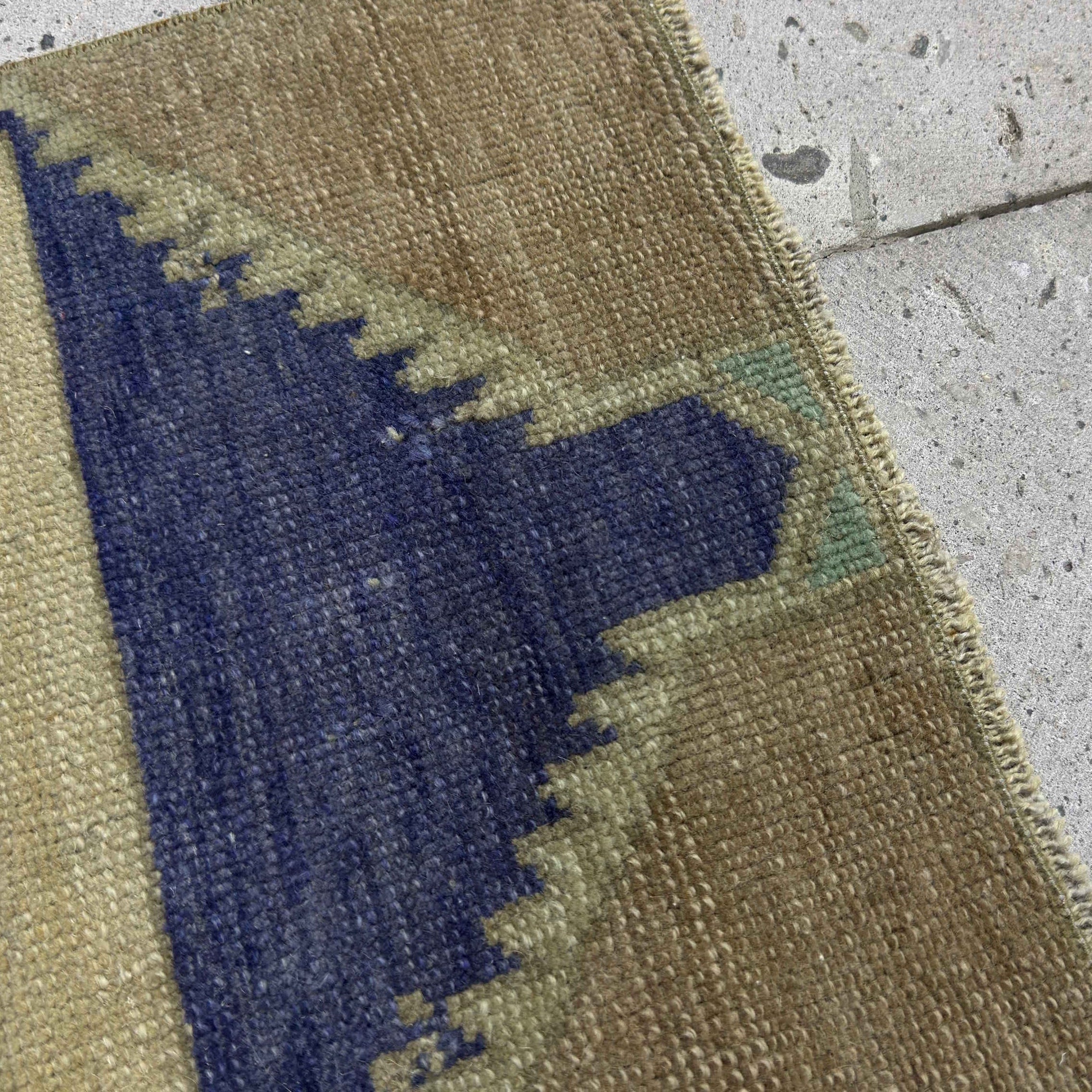Close-up of the blue vintage Turkish small rug showing neutral details, hand-knotted weave, wool and cotton and low pile.