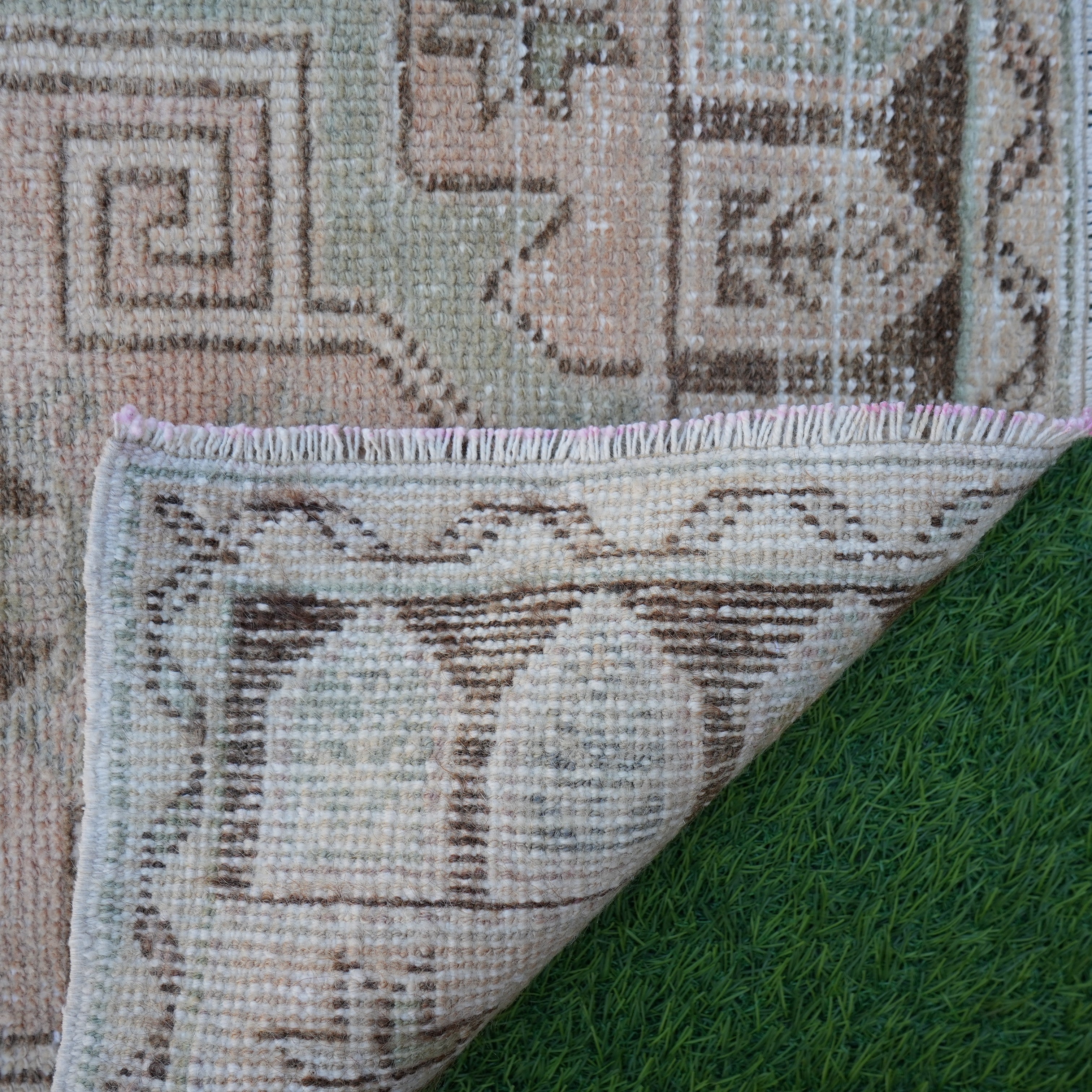 1970s pink vintage Turkish small rug with neutral design, hand-knotted weave and low pile.