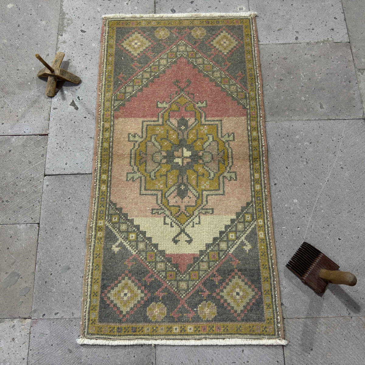 Pink 2' x 3' vintage Turkish small rug in wool and cotton, shown on the floor.