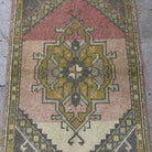 1970s pink vintage Turkish small rug with traditional design, hand-knotted weave and low pile.