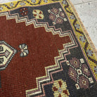Close-up of the red vintage Turkish small rug showing traditional details, hand-knotted weave, wool and cotton and low pile.