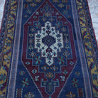 Close-up of the blue vintage Turkish tradiitonal rug showing traditional details, hand-knotted weave, wool and cotton and low pile.