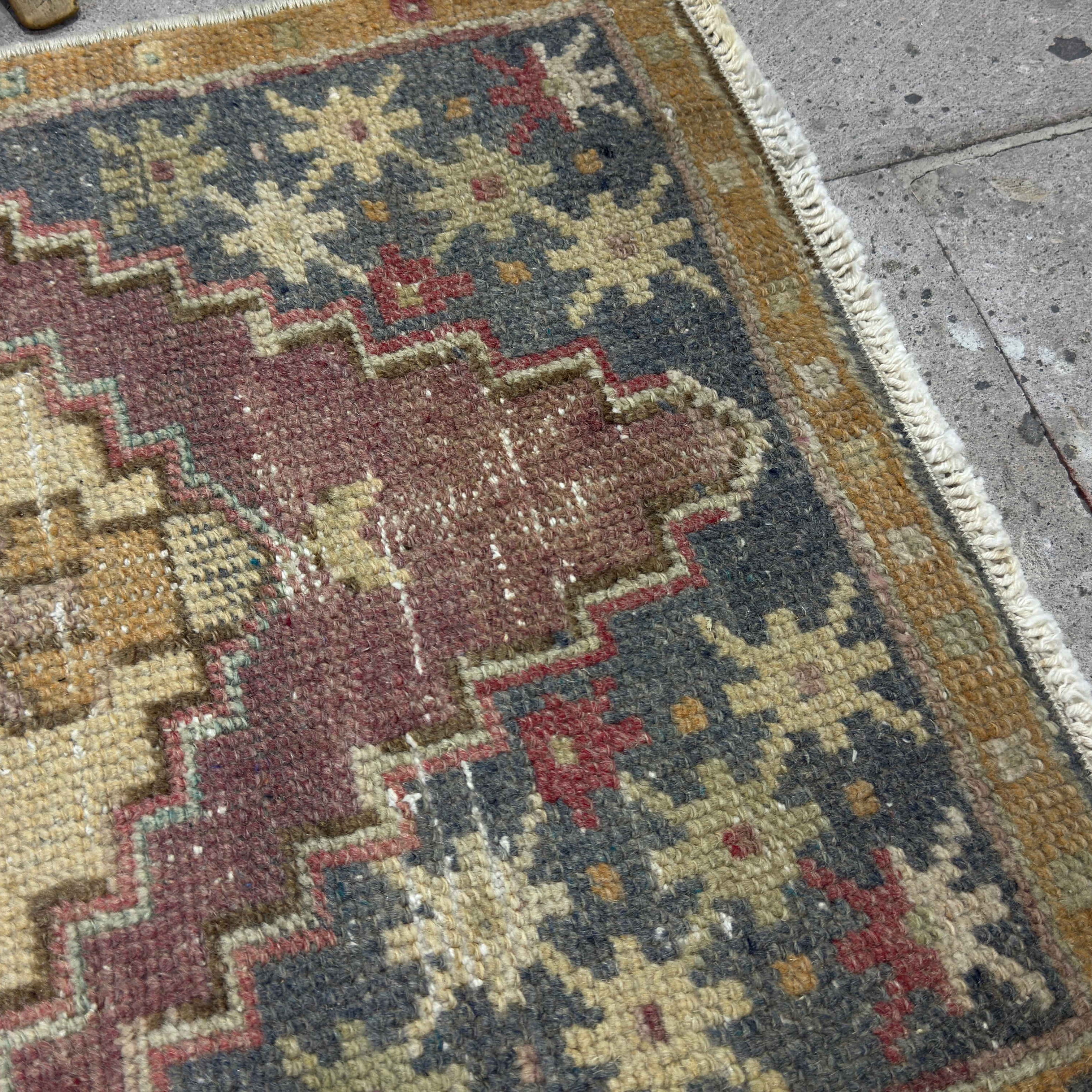 Close-up of the gray vintage Turkish traditional rug showing traditional details, hand-knotted weave, wool and cotton and low pile.
