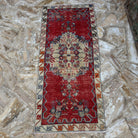 Close-up of the red vintage Turkish traditional rug showing traditional details, hand-knotted weave, wool and cotton and low pile.