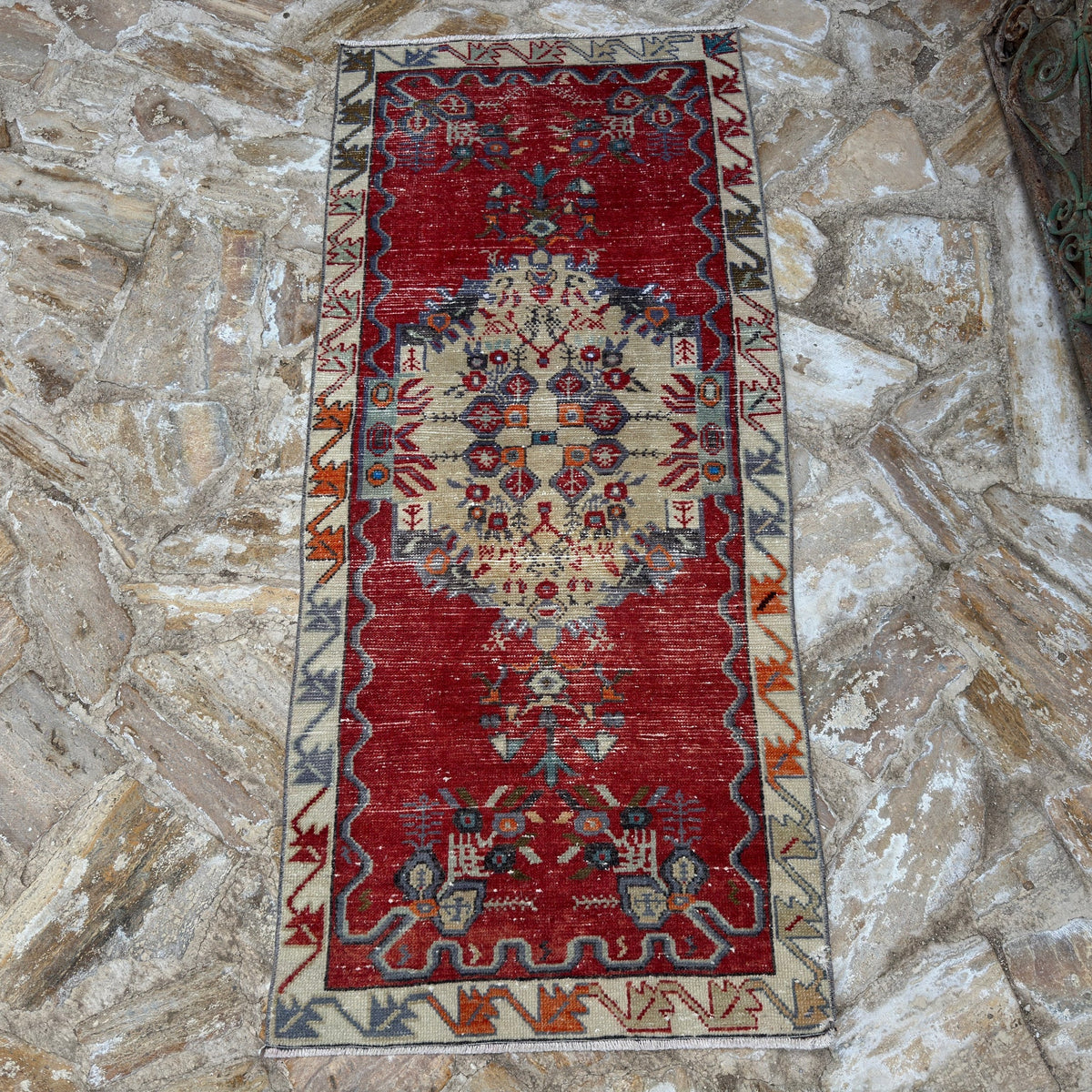 Close-up of the red vintage Turkish traditional rug showing traditional details, hand-knotted weave, wool and cotton and low pile.